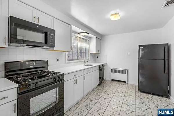 a kitchen with stainless steel appliances a refrigerator stove and microwave