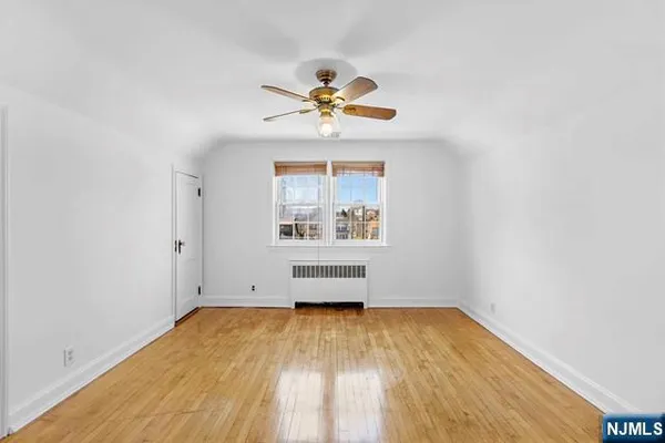 an empty room with a window and wooden floor