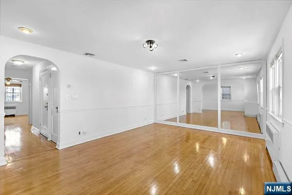 a view of empty room with wooden floor
