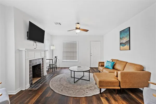 a living room with furniture a fireplace and a flat screen tv