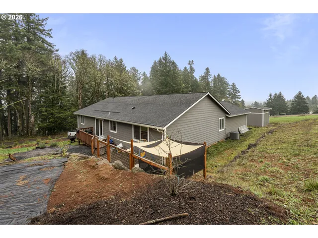 a aerial view of a house with a yard and trees in the background