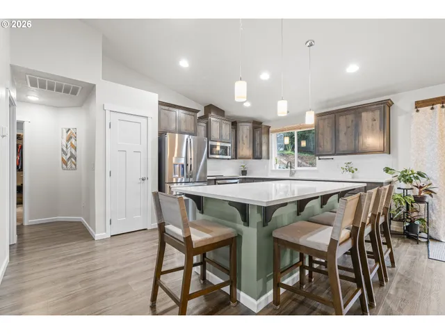 a kitchen with kitchen island a table and chairs in it