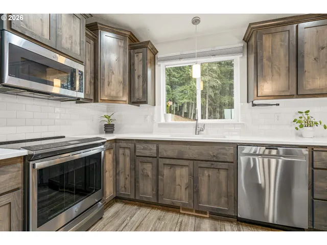 a kitchen with granite countertop a stove a sink and a microwave