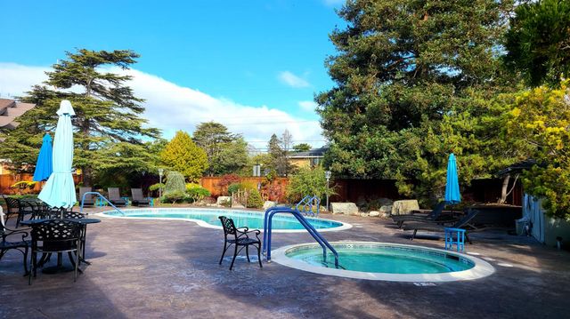 a swimming pool with outdoor seating and trees