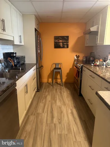 a kitchen with sink a stove and cabinets