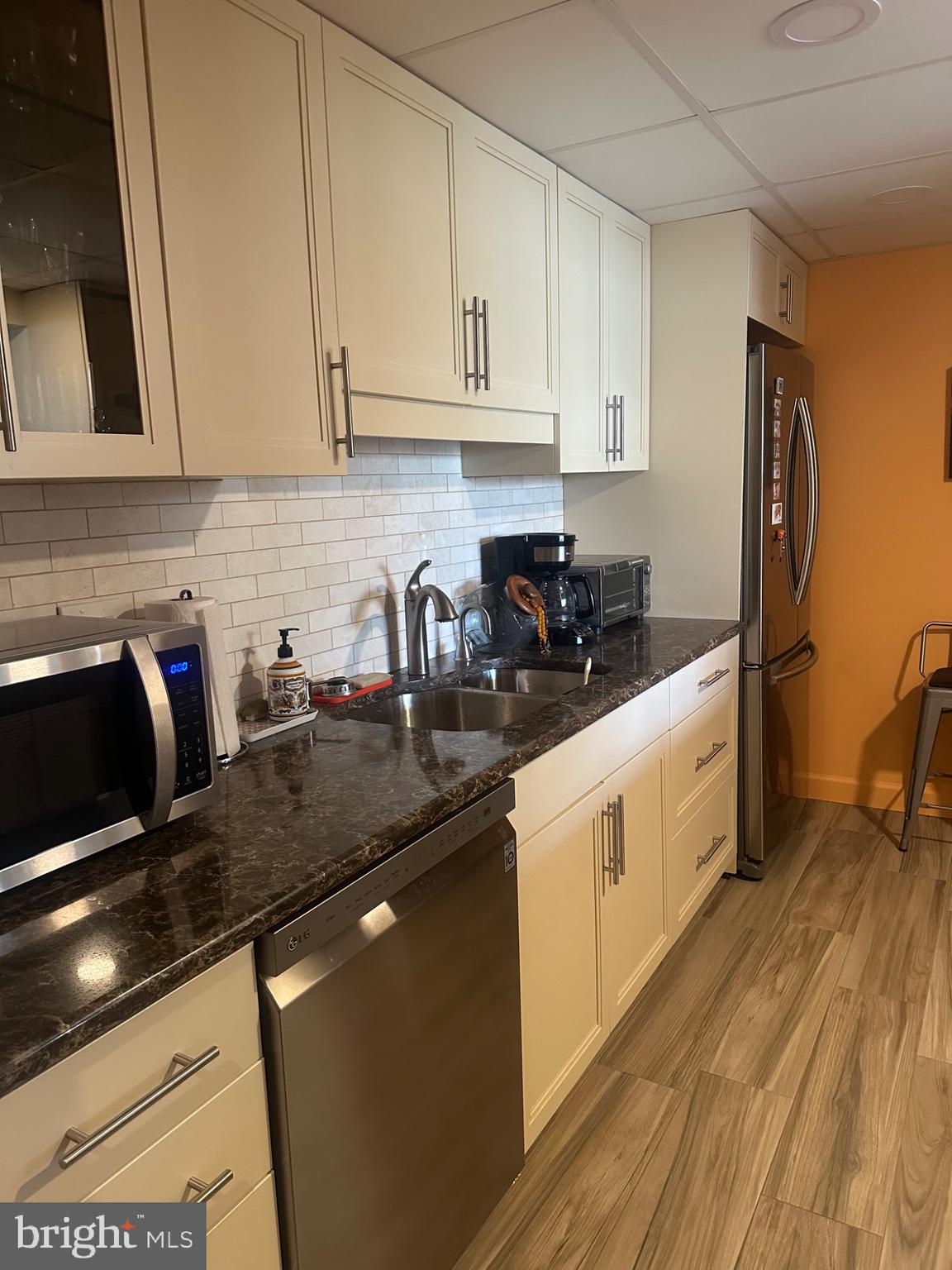 1 Markham Road, Unit 1D Princeton, NJ 08540 - Photo 9 of 49 a kitchen with stainless steel appliances granite countertop a sink a stove and white cabinets with wooden floor