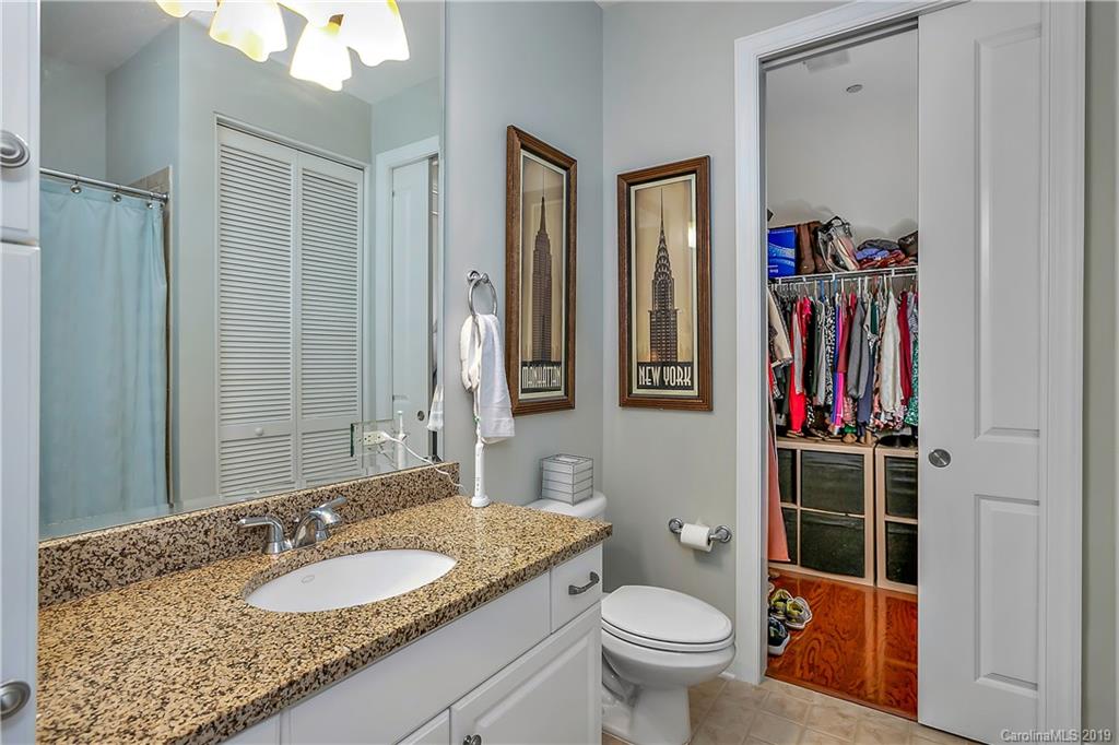 230 South Tryon Street, Unit 703 Charlotte, NC 28202 - Photo 13 of 22 a bathroom with a granite countertop sink and a mirror
