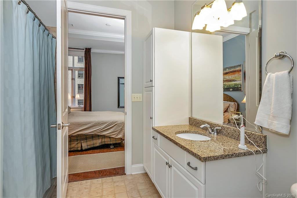 230 South Tryon Street, Unit 703 Charlotte, NC 28202 - Photo 14 of 22 a en suite bathroom with a sink and mirror