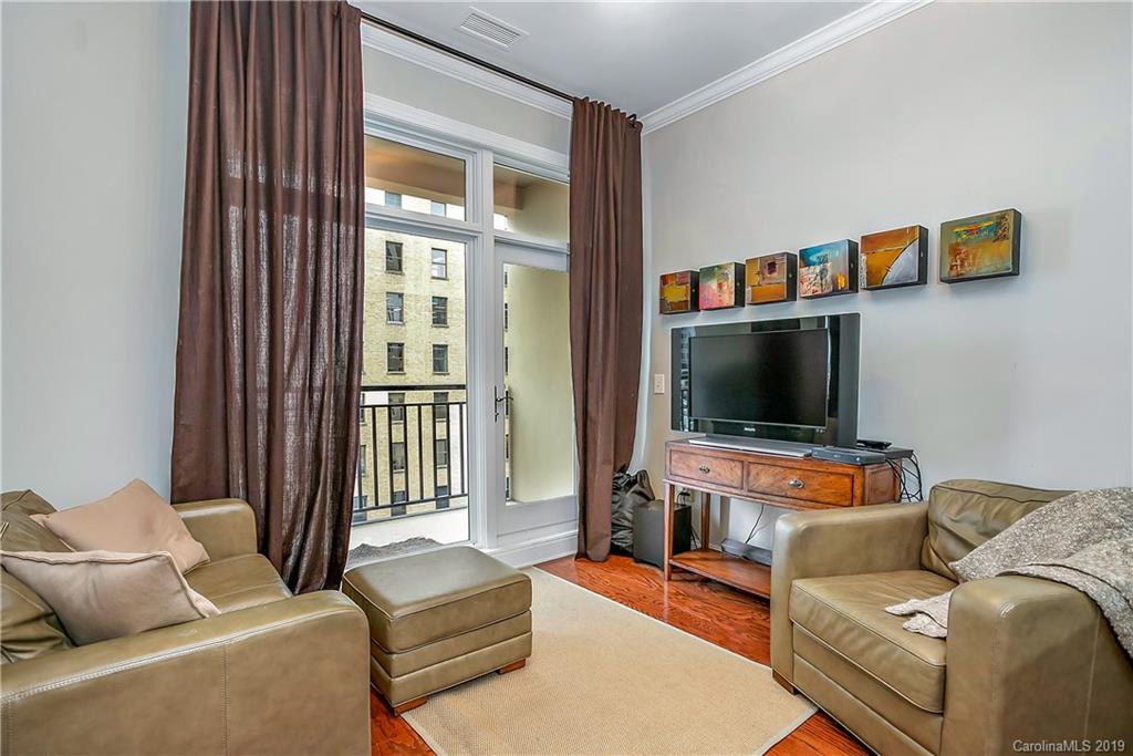 230 South Tryon Street, Unit 703 Charlotte, NC 28202 - Photo 5 of 22 a living room with furniture and a flat screen tv