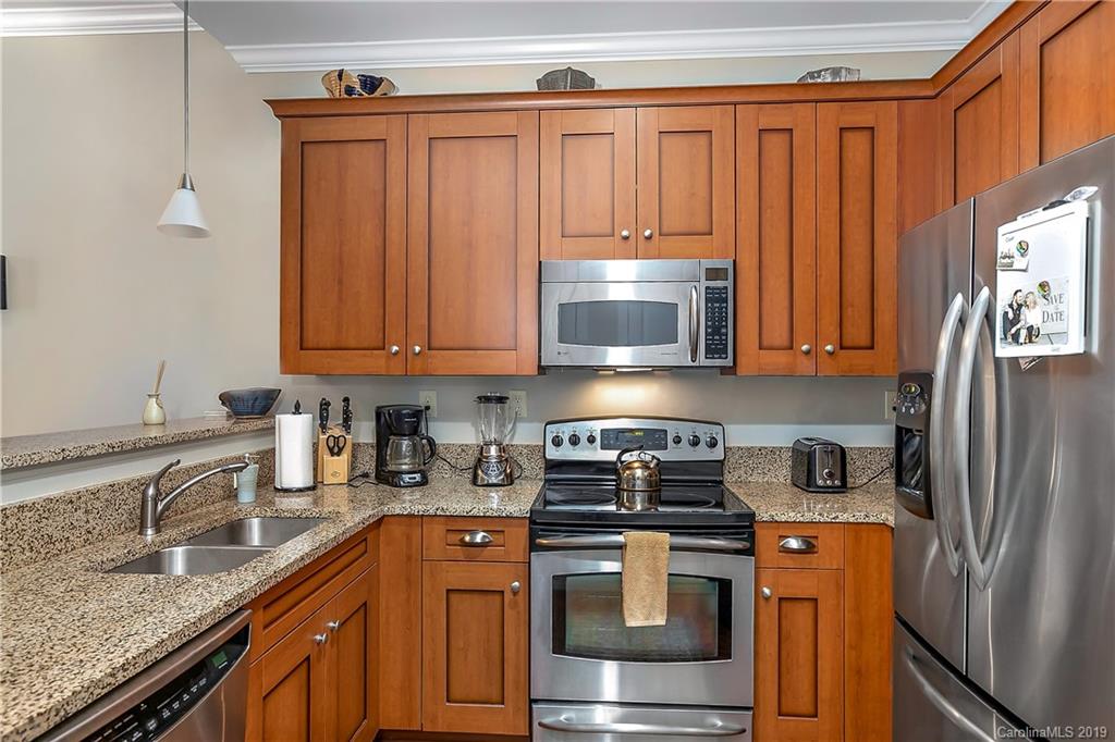 230 South Tryon Street, Unit 703 Charlotte, NC 28202 - Photo 8 of 22 a kitchen with stainless steel appliances granite countertop a refrigerator stove and sink