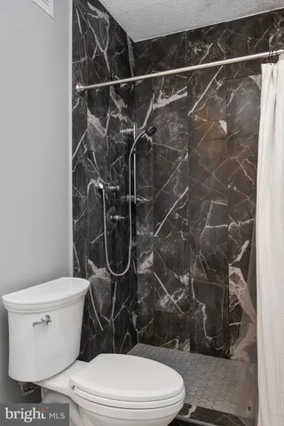 a view of a livingroom with a fireplace wooden floor and windows