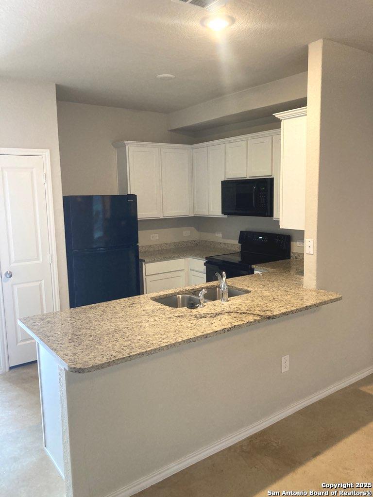 3815 Key W Way, Unit 1 Converse, TX 78109 - Photo 3 of 11 a kitchen with granite countertop a refrigerator and a sink