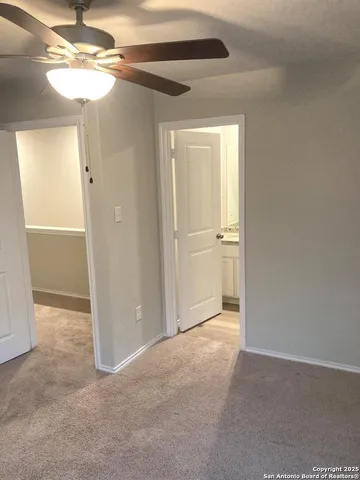 an empty room with closet and a chandelier fan