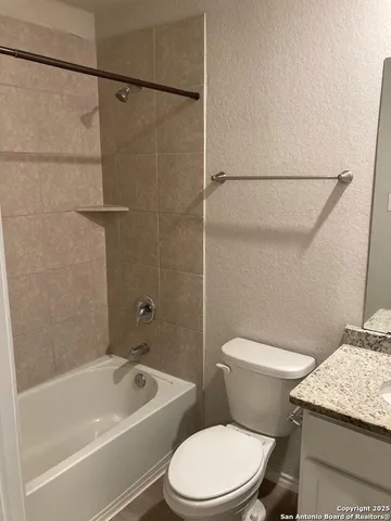a white toilet and tub sitting next to a bathroom sink