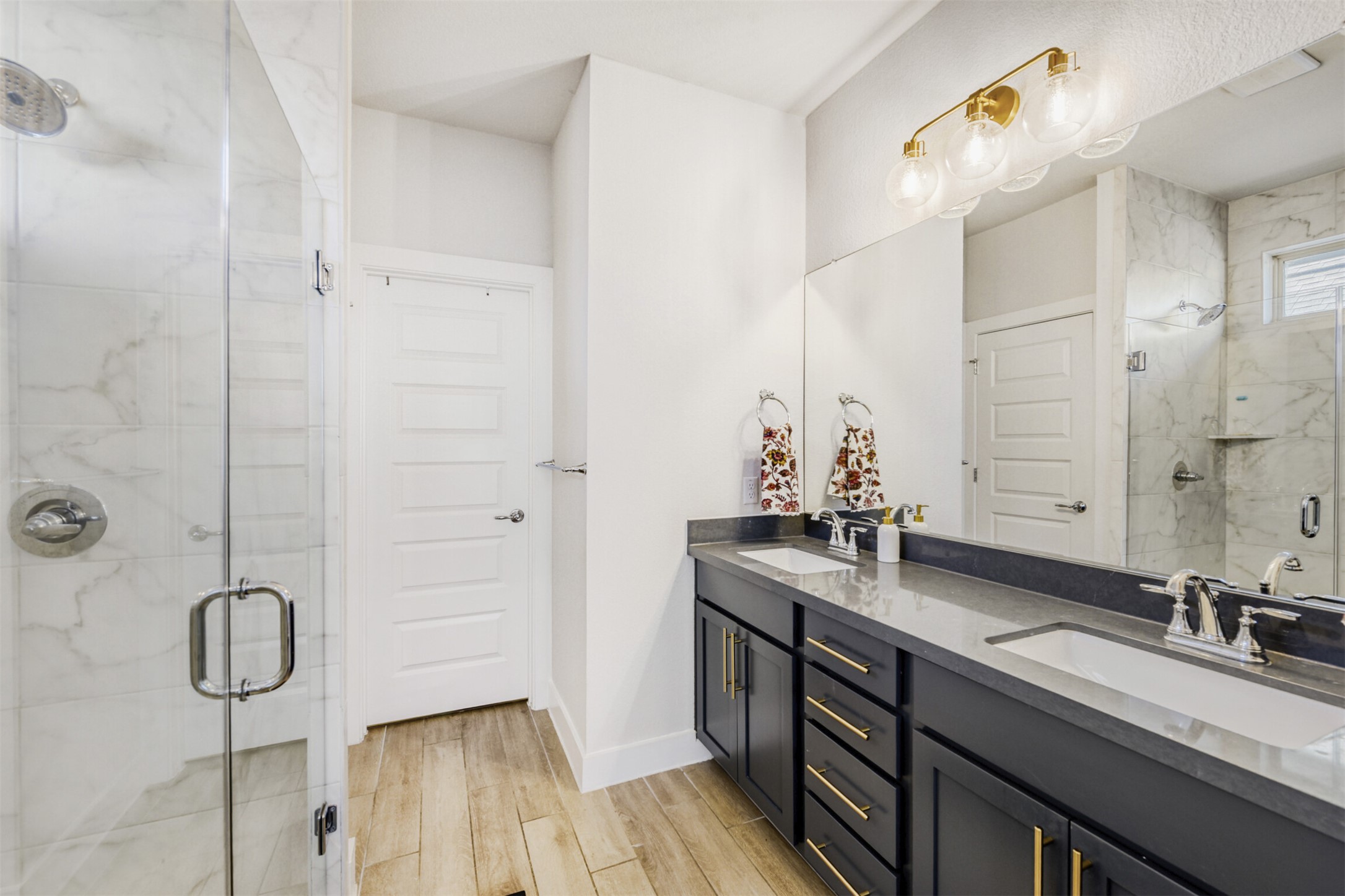 8602 Cottage Rose Drive Austin, TX 78744 - Photo 14 of 17 Full bath featuring a marble finish shower, double vanity, and light wood-type flooring