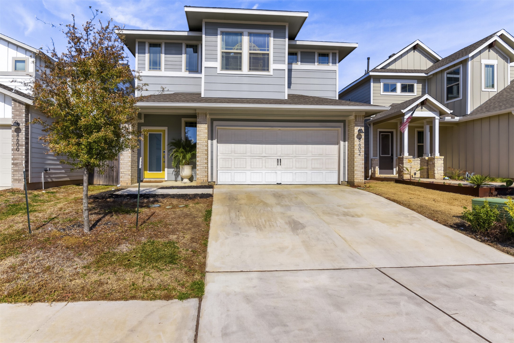 8602 Cottage Rose Drive Austin, TX 78744 - Photo 2 of 17 View of front facade featuring concrete driveway, an attached garage, and brick siding