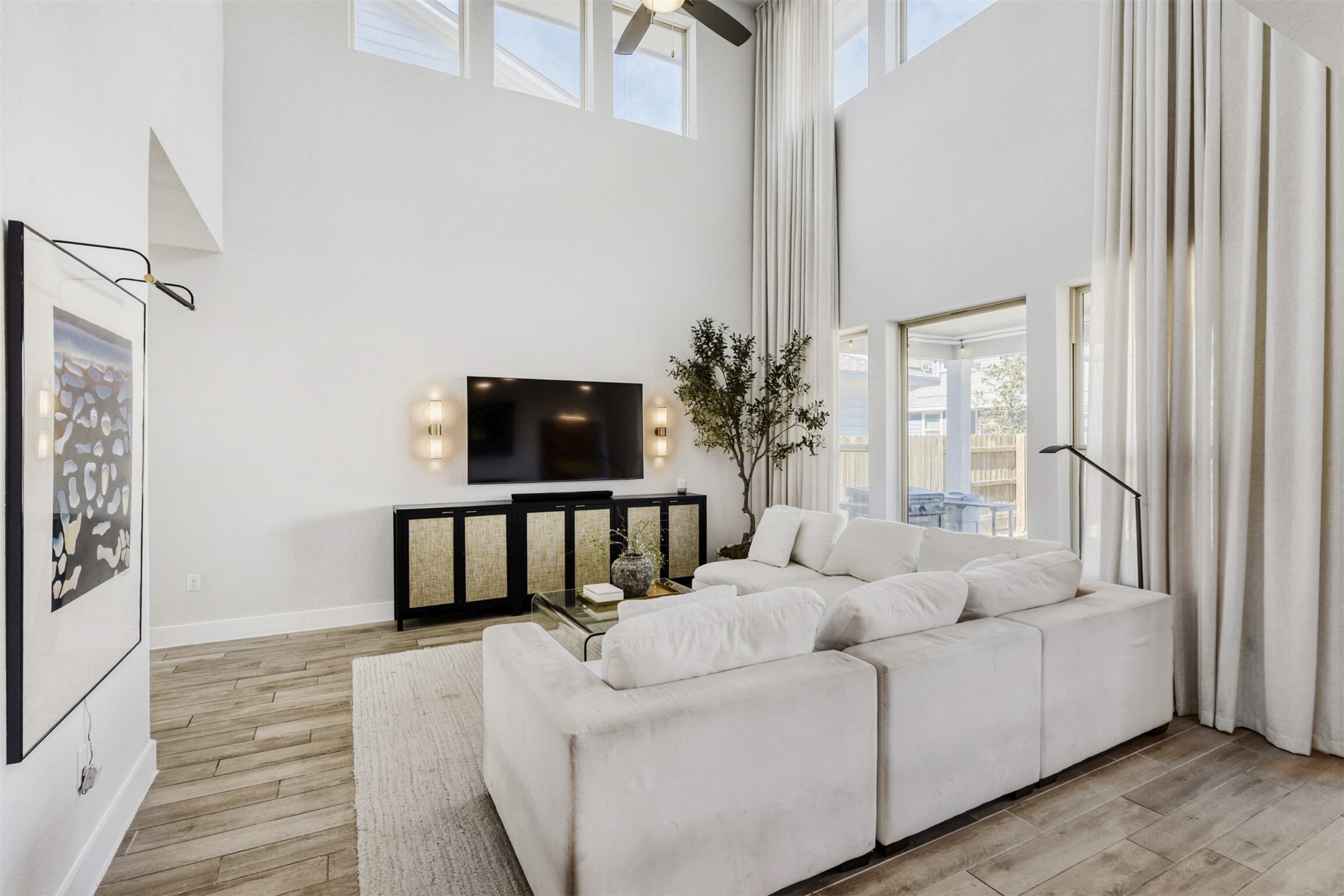 8602 Cottage Rose Drive Austin, TX 78744 - Photo 9 of 17 Living area featuring light wood-style flooring, ceiling fan, and a high ceiling
