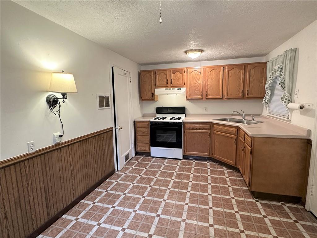 89 Thomas Street Crafton, PA 15205 - Photo 3 of 13 a kitchen with stainless steel appliances a sink a stove a refrigerator cabinets and a window