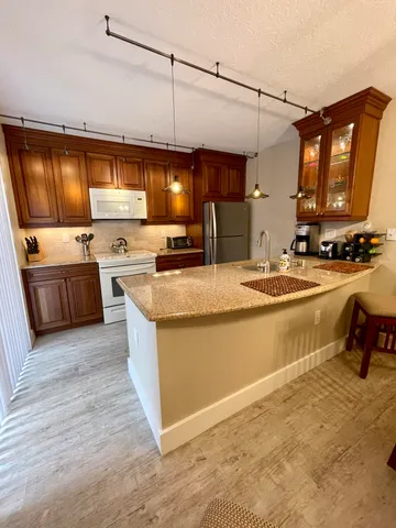 a kitchen with stainless steel appliances granite countertop a stove a sink and a refrigerator