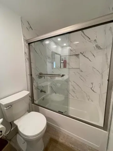 a bathroom with a toilet and a shower