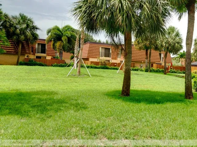 a view of a backyard with a garden and palm trees