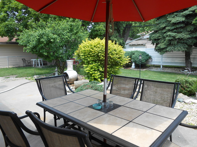 18363 Bock Road Lansing, IL 60438 - Photo 3 of 15 a view of a patio with table and chairs under an umbrella with potted plants