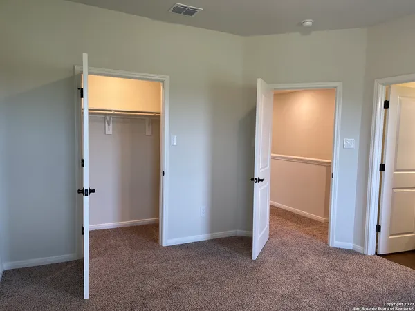 an empty room with closet and a bathroom