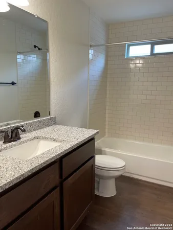 a bathroom with a granite countertop toilet a sink and bathtub