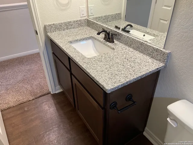 a bathroom with a granite countertop sink and a mirror