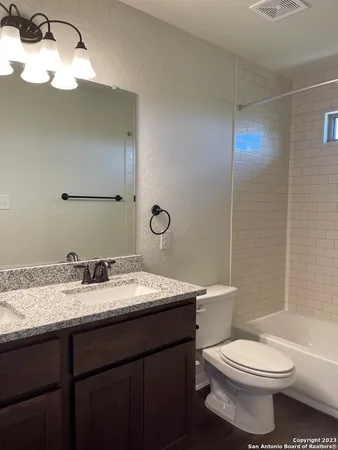 a bathroom with a toilet a sink and mirror
