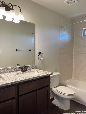 a bathroom with a toilet a sink and mirror