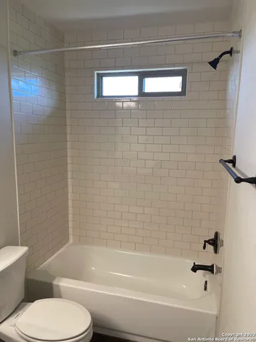 a bathroom with a toilet and a bathtub