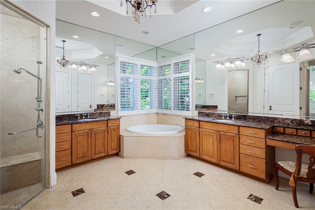 122 Caribbean Road Naples, FL 34108 - Photo 11 of 31 a large spacious bathroom with a granite countertop tub sink shower and mirror