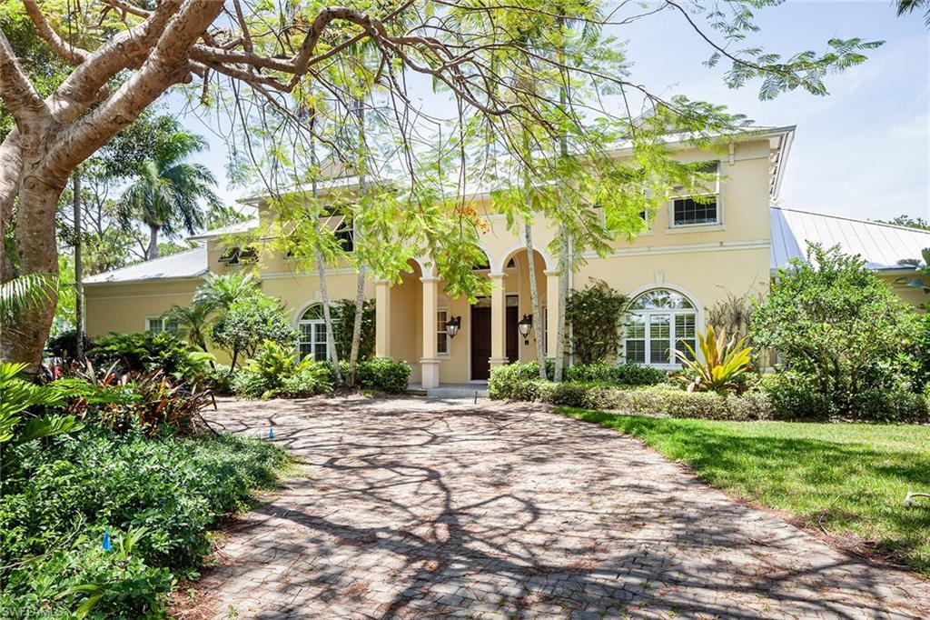 122 Caribbean Road Naples, FL 34108 - Photo 2 of 31 a front view of a house with a garden