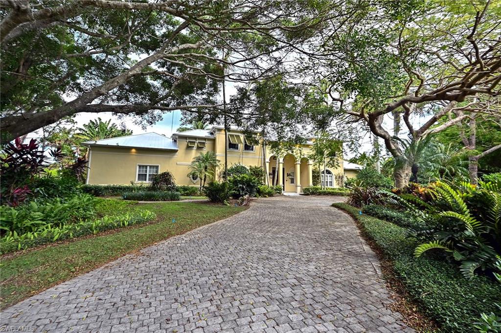 122 Caribbean Road Naples, FL 34108 - Photo 24 of 31 a front view of a house with yard and green space