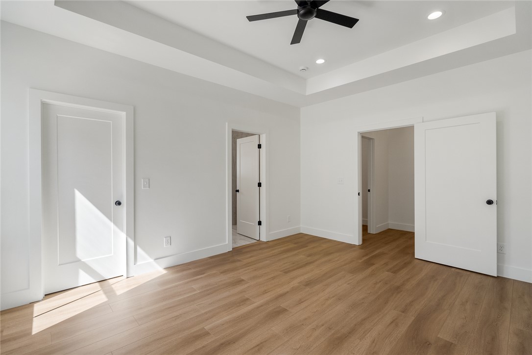 2125 A Honea Path Park Road Anderson, SC 29625 - Photo 13 of 26 This spacious bedroom features warm wood flooring and ample natural light, creating a bright and inviting atmosphere.