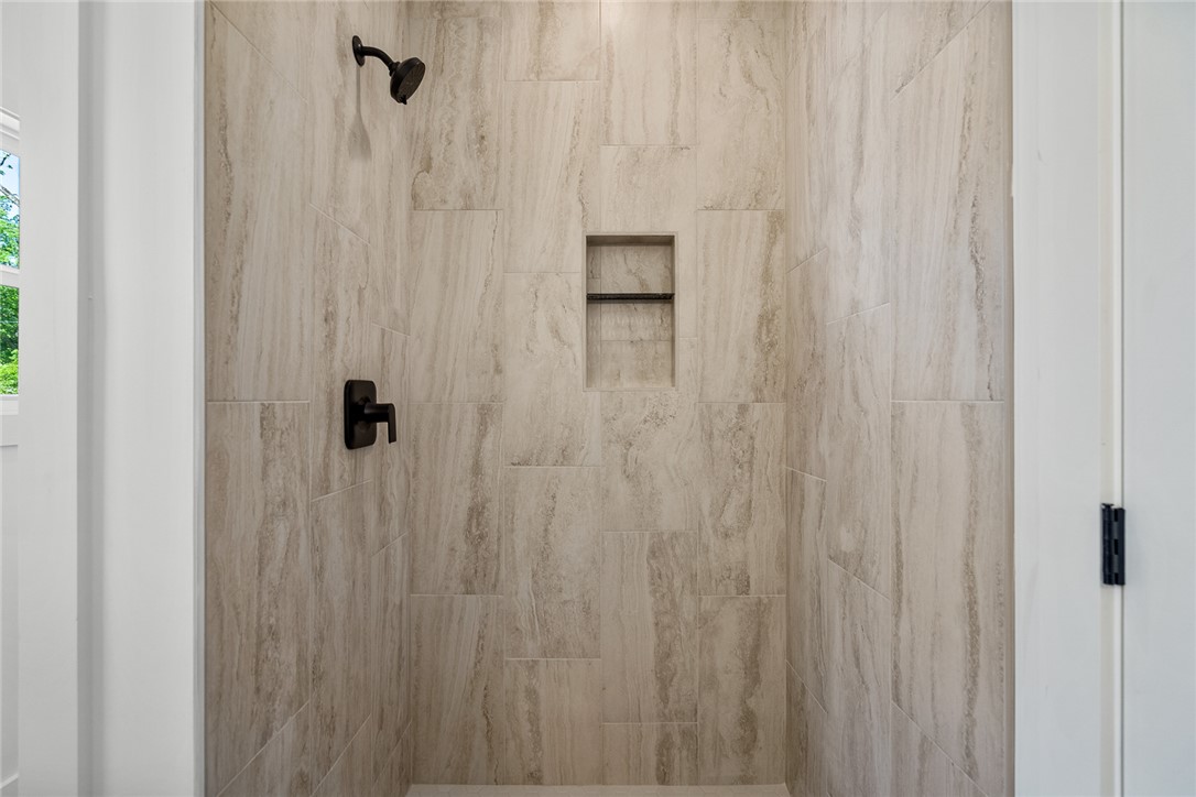 2125 A Honea Path Park Road Anderson, SC 29625 - Photo 15 of 26 This bathroom features a contemporary tiled shower with integrated shelving, creating a sleek aesthetic.