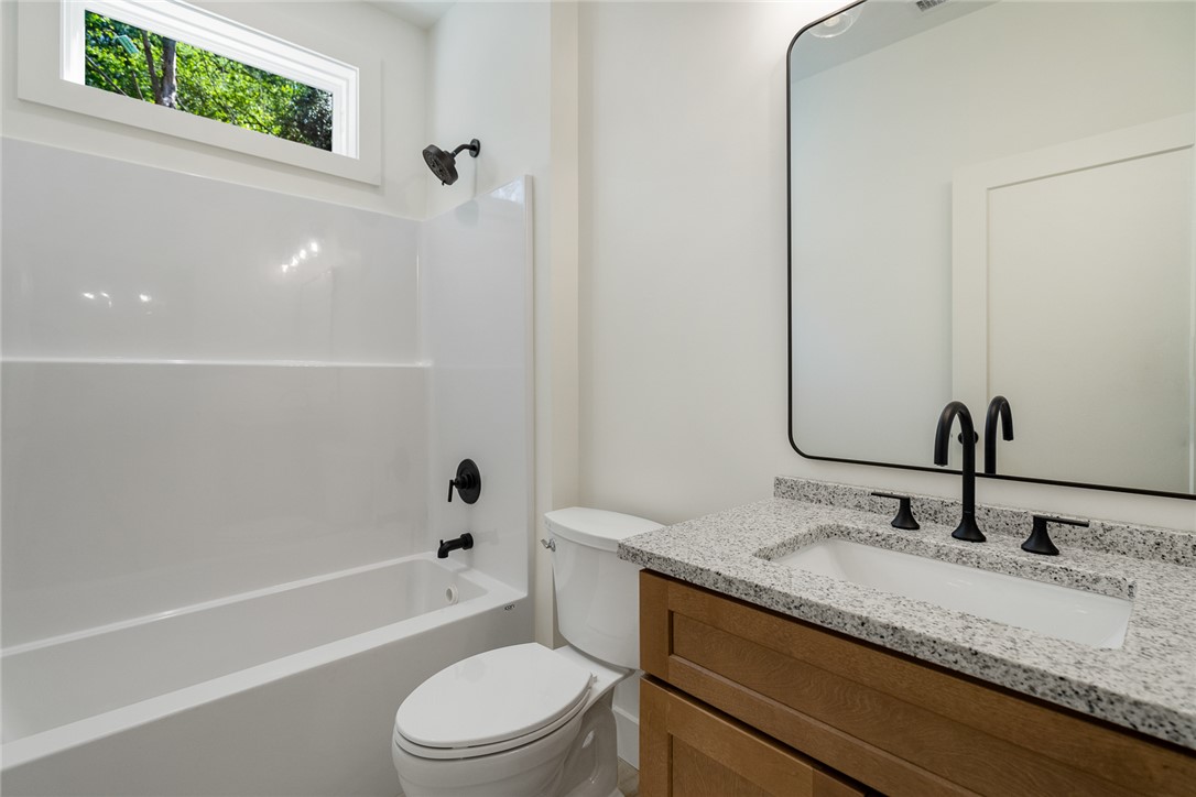 2125 A Honea Path Park Road Anderson, SC 29625 - Photo 18 of 26 This bright bathroom features a vanity with granite counters and a clean tub-shower combination.