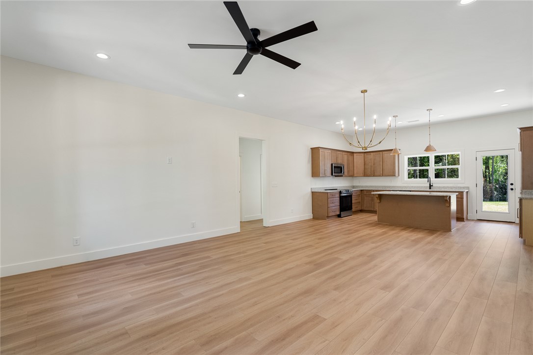 2125 A Honea Path Park Road Anderson, SC 29625 - Photo 5 of 26 This expansive open-concept room features light wood flooring and a luminous kitchen area.