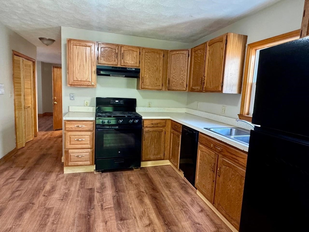 68 Maverick Street Chelsea, MA 02150 - Photo 2 of 16 a kitchen with a refrigerator stove and wooden cabinets