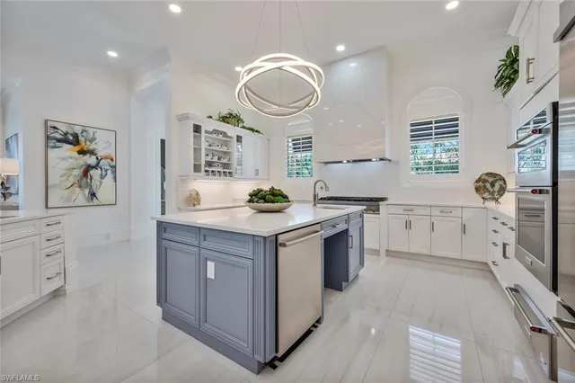 a kitchen with white cabinets and appliances