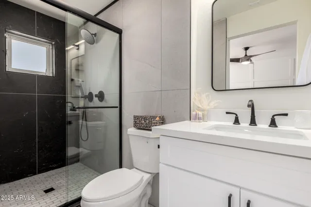 a bathroom with a sink a toilet and shower