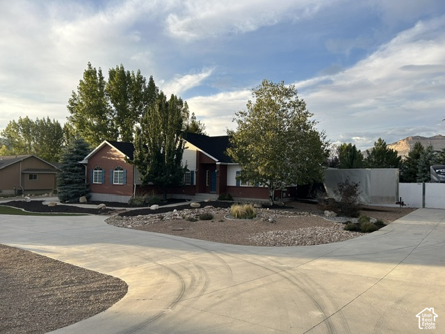 1750 West 4100 North Helper, UT 84526 - Photo 14 of 50 Brick and siding exterior with dark shutters, established landscaping, mature trees, and a spacious concrete driveway