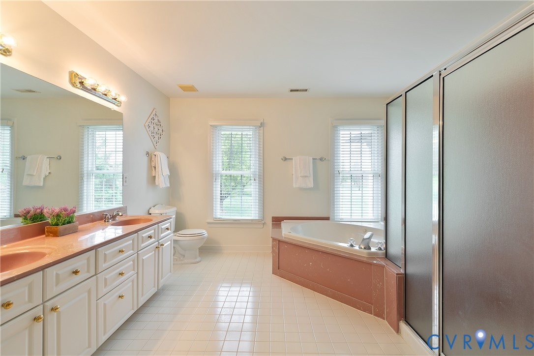 2130 Manakin Road Manakin-Sabot, VA 23103 - Photo 33 of 65 a large bathroom with a double vanity sink a large mirror and a bathtub with shower