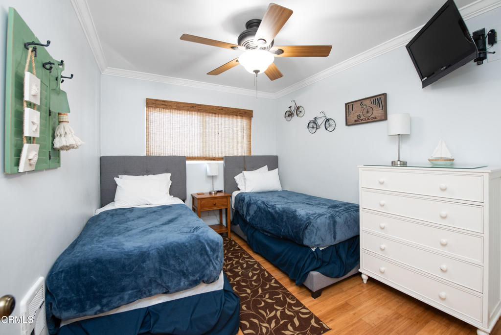 4975 Sandyland Road, Unit 302 Carpinteria, CA 93013 - Photo 14 of 28 a bedroom with a bed and flat screen tv