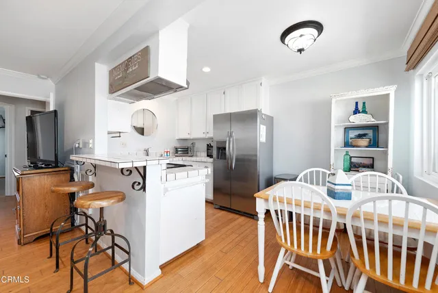 a kitchen with a table chairs refrigerator and microwave