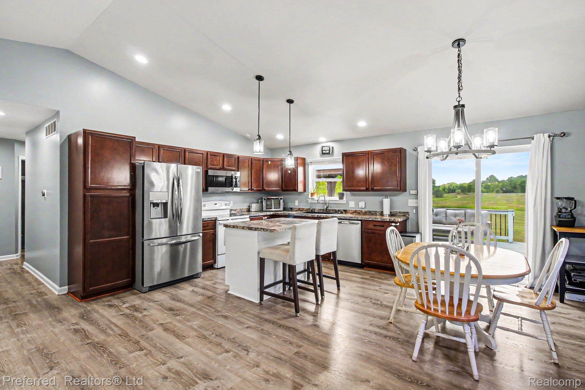 6366 Dutcher Road Howell, MI 48843 - Photo 12 of 33 Open-concept kitchen featuring wood-finish flooring, vaulted ceilings, and recessed lighting