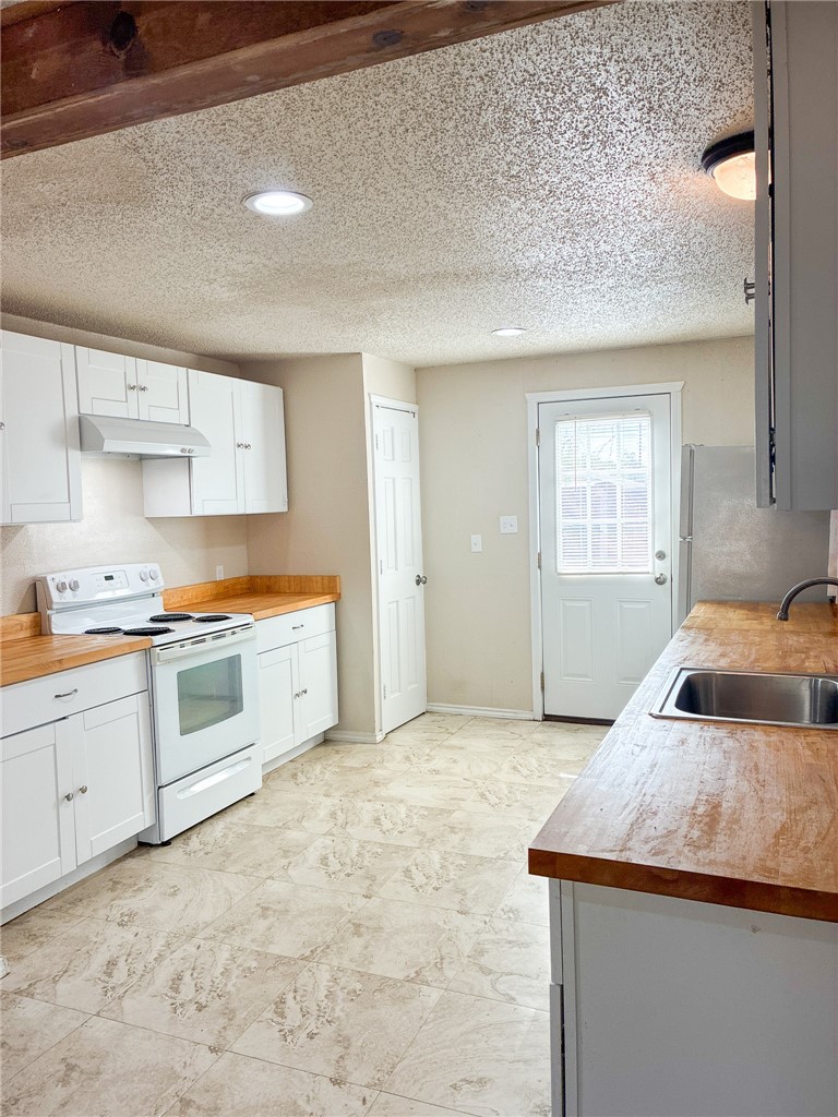 Undisclosed Address Three Rivers, TX 78071 - Photo 2 of 12 a kitchen with granite countertop a sink a stove and cabinets
