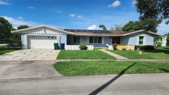 a view of a house with a yard and potted plants
