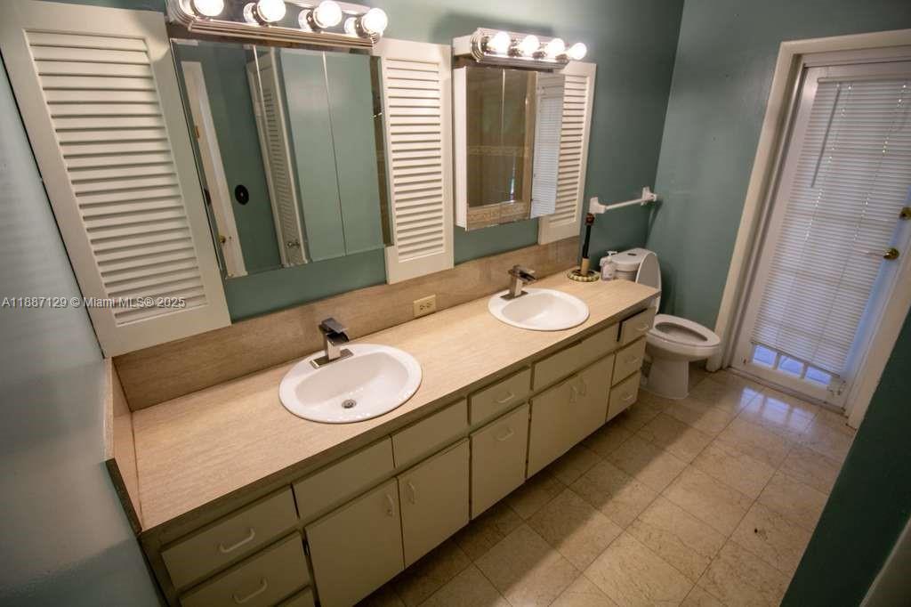 9041 Southwest 88th Street, Unit 9041 Miami, FL 33173 - Photo 22 of 34 a bathroom with a double vanity sink and a mirror
